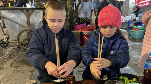 Sharing a bowl of phở with the kids on a street food trip